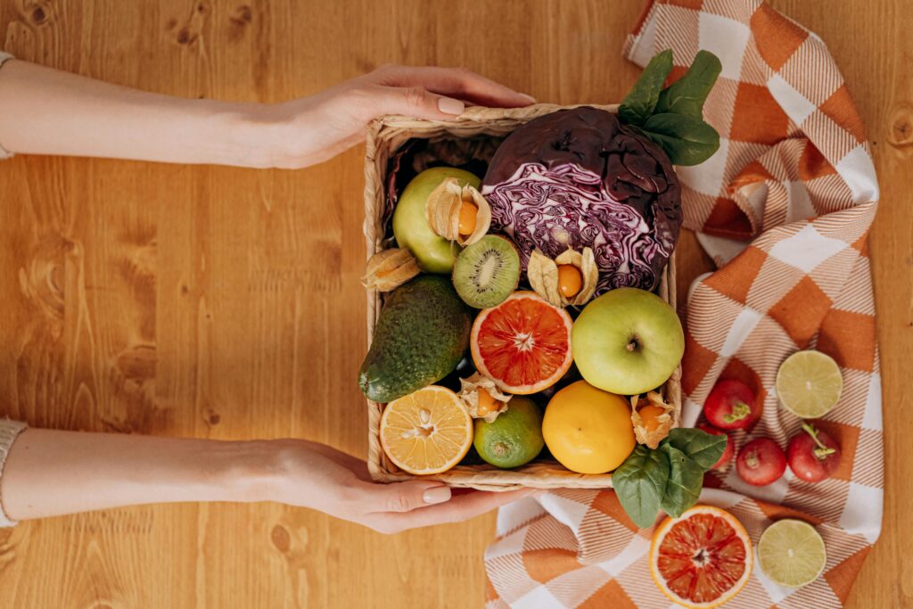 Hands holding fresh fruit and vegetables for skin-friendly nutrition